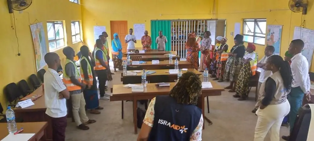 Participantes de pé durante uma dinâmica numa formação sobre inclusão da deficiência