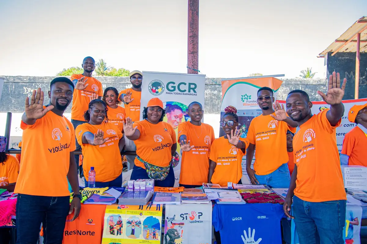 Equipa e activistas da GCR com camisetas laranja fazem o gesto de basta, no lançamento dos 16 Dias de Activismo