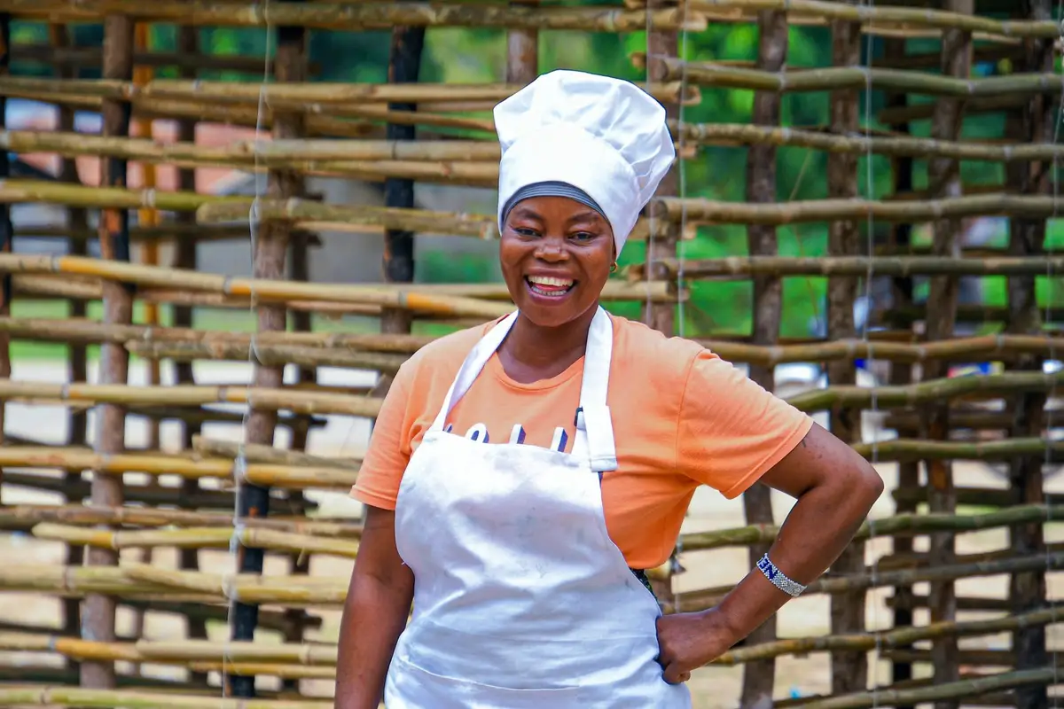 Mulher sorridente de chapéu de cozinheira e avental